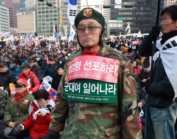 지난 2017년 1월 서울 종로구 대한문 앞에서 열린 '대통령 탄핵 기각을 위한 국민 총궐기대회'에서 '계엄령 선포' 피켓을 몸에 매단 참가자.