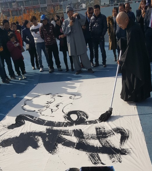 지난 19년 5월, 강북구민운동장에서 개최된 '강북구 장애인 어울림 한마당'에서 대일스님이 달마 작품으로 재능기부를 하고 있다.