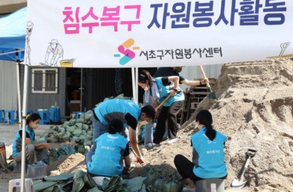 SPC그룹 임직원이 지난 12일 서울 서초구 반포종합운동장에서 하천 범람 방지를 위한 모래주머니를 만들고 있다@ SPC