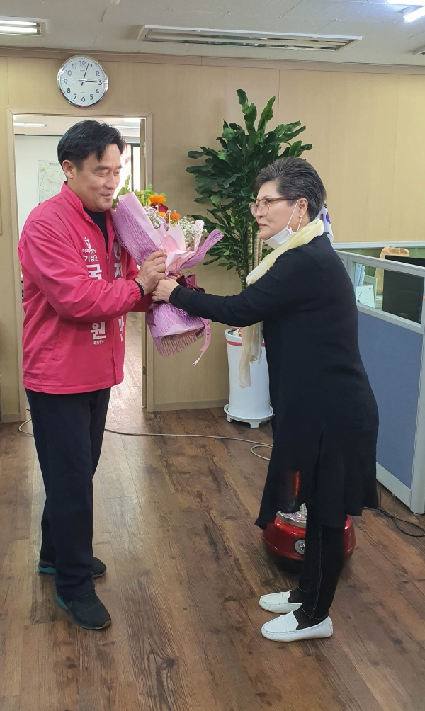 당원들이 경선 승리 축하 꽃다발을 건네고 있다(기장군 정동만후보 사무실)